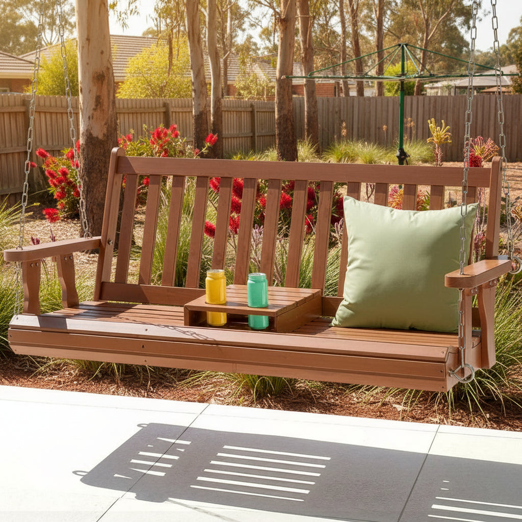 Wooden swing bench with a green pillow on a patio near a pool