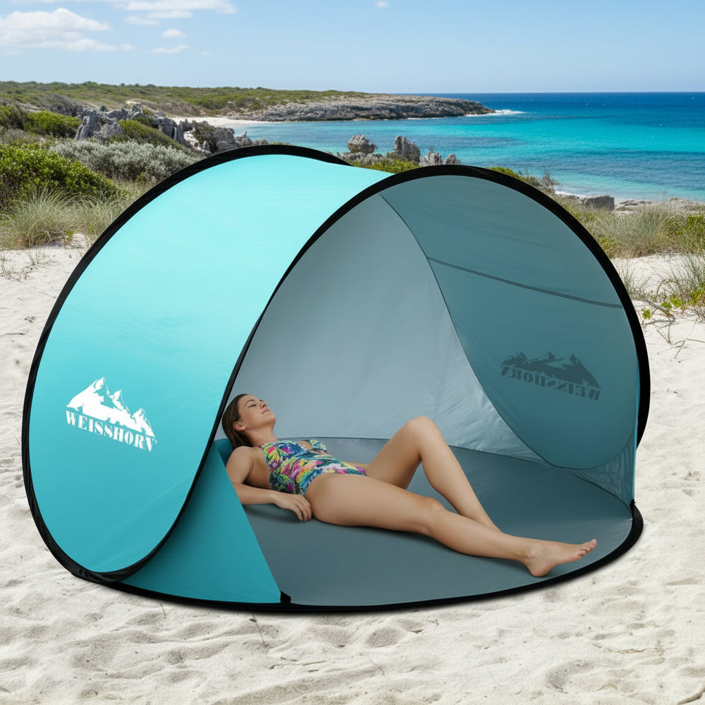 Pop-up beach tent on a sandy beach with palm trees and ocean in the background