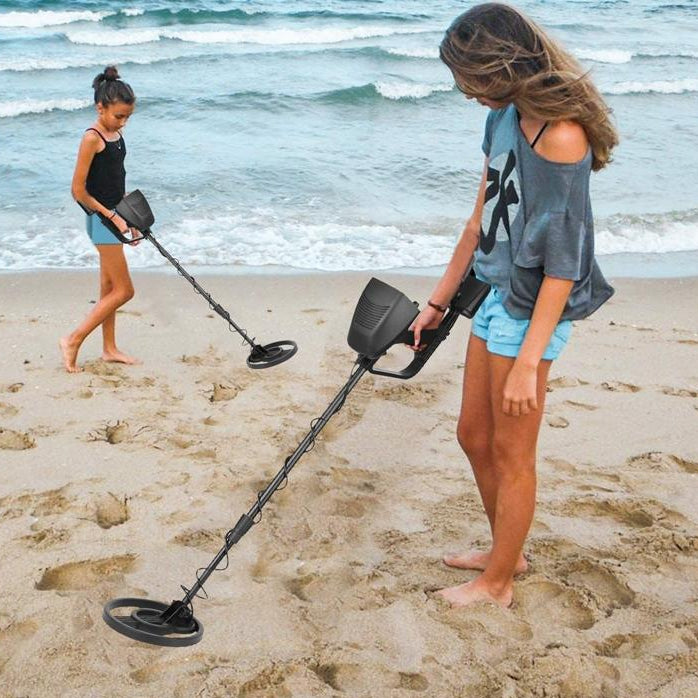 Two people using metal detectors on a beach with text about adjustable height.